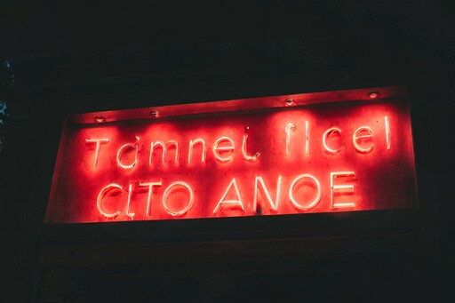 빨간색 네온 표지판이 있습니다. Tammel Ficel cito angel라는 표지판